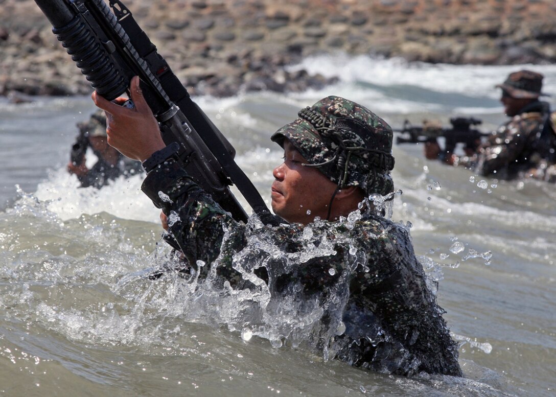 Philippine Marines and U.S. Marines assigned to Fleet Anti-terrorism Security Team (FAST) Pacific, fight against the waves on their way ashore during an amphibious beach assault exercise for Cooperation Afloat Readiness and Training (CARAT) Philippines 2012. CARAT is a series of bilateral military exercises between the U.S. Navy and the armed forces of Bangladesh, Brunei, Cambodia, Indonesia, Malaysia, the Philippines, Singapore, and Thailand. The Marine Corps Security Force Regiment maintains FAST companies and deploys personnel to provide expeditionary antiterrorism and security forces in support of combatant commanders and to protect vital naval and national assets.