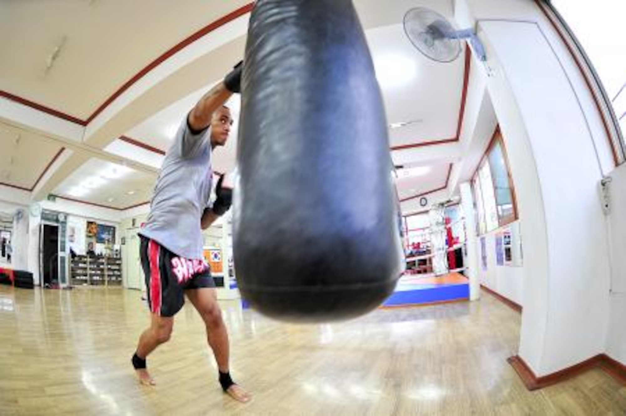 Senior Airman James Turner, 51st Maintenance Group aircraft metal technology journeyman, punches a punching bag before sparring June 18, 2012. Muay Thai kickboxing is a combative sport from Thailand that uses stand-up striking along with various clinching techniques similar to other Indochinese kickboxing systems. (U.S. Air Force photo/Senior Airman Adam Grant)

