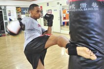 Senior Airman James Turner, 51st Maintenance Group aircraft metal technology journeyman, kicks a punching bag before sparring June 18, 2012. Muay Thai kickboxing is a combative sport from Thailand that uses stand-up striking along with various clinching techniques similar to other Indochinese kickboxing systems. (U.S. Air Force photo/Senior Airman Adam Grant)
