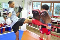 Senior Airman James Turner, 51st Maintenance Group aircraft metal technology journeyman, practices kicking while sparring with Grand Master Myong Chae Kim, June 18, 2012. Kim has 30 years of experience and has trained more than 500 airmen, five of whom have competed at national level. (U.S. Air Force photo/Senior Airman Adam Grant)
