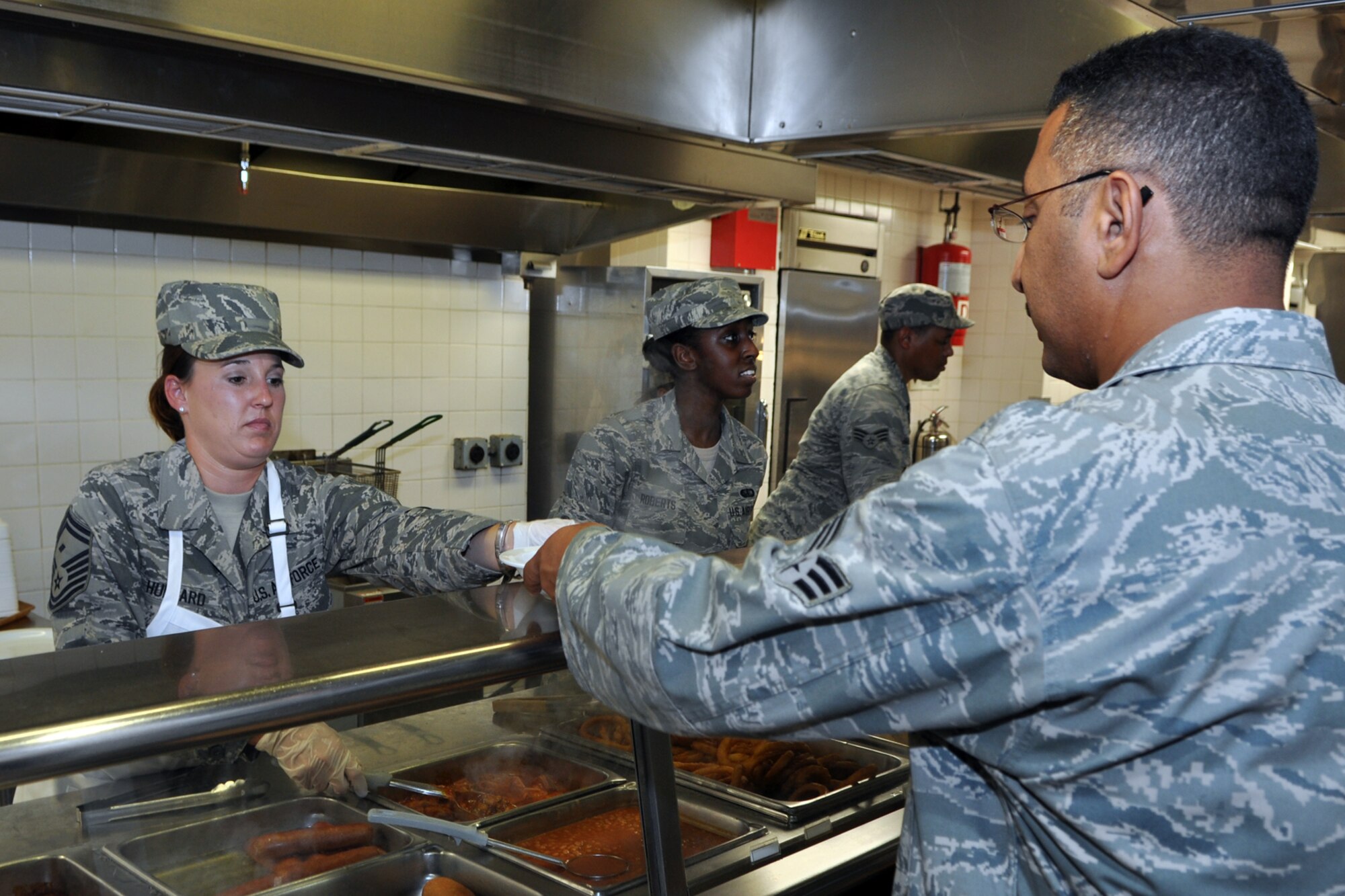Senior Master Sgt. Melissa Hubbard, first sergeant, 307th Civil Engineer Squadron, 307th Bomb Wing, serves up hot meals at the dining facility on Barksdale Air Force Base, La., July 8, 2012. First sergeants and chiefs from the 307 BW served lunch to Barksdale Airmen during the July Unit Training Assembly (UTA) weekend to promote esprit de corps. The chiefs served meals on Saturday, July 7. (U.S. Air Force photo by Master Sgt. Jeff Walston)   