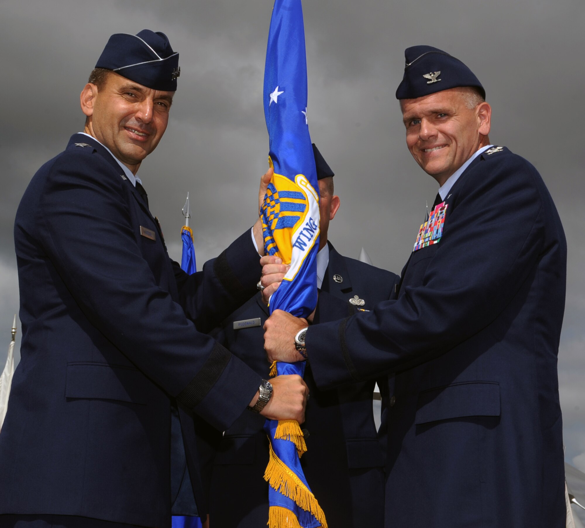 Lt. Gen. Ted Kresge, 13th Air Force commander, hands the 15th Wing command guidon to Col. Johnny Roscoe, incoming 15th WG commander, upon his assumption of command during the start of the 15th Wing Change of Command ceremony July 6 at Joint Base Pearl Harbor-Hickam, Hawaii. During the ceremony, command of the 15th WG passed from Col. Sam Barrett to Roscoe. (U.S. Air Force photo by Staff Sgt. Nathan Allen)