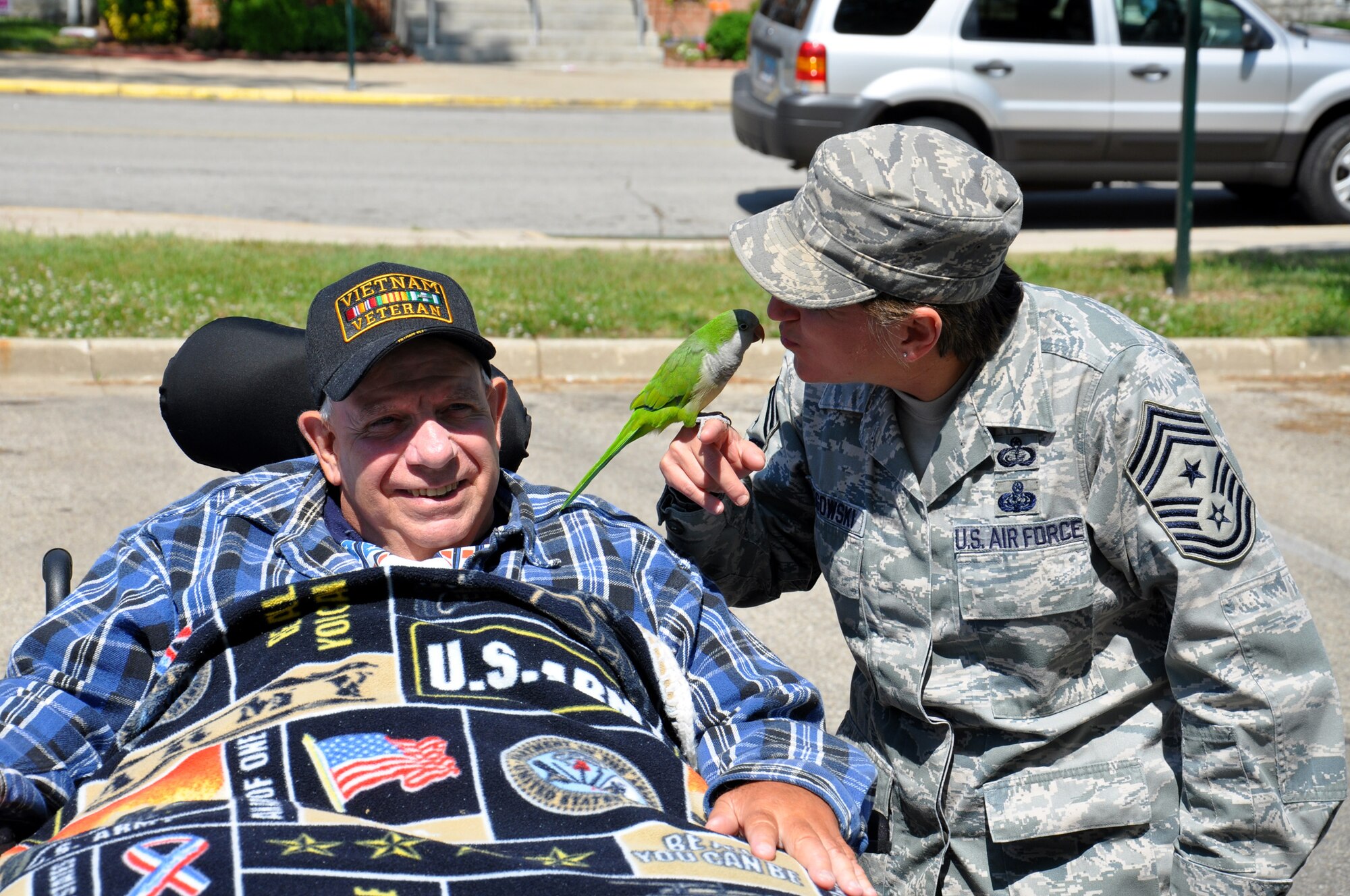 WRIGHT-PATTERSON AIR FORCE BASE, Ohio – Chief Master Sgt. Peri Rogowski, 445th Airlift Wing command chief, enjoys the afternoon with veteran Donald Vinton and his Quaker parrot, Cricket, at the Dayton Veterans Affairs Medical Center annual picnic June 2. (U.S. Air Force photo/Master Sgt. Charlie Miller)