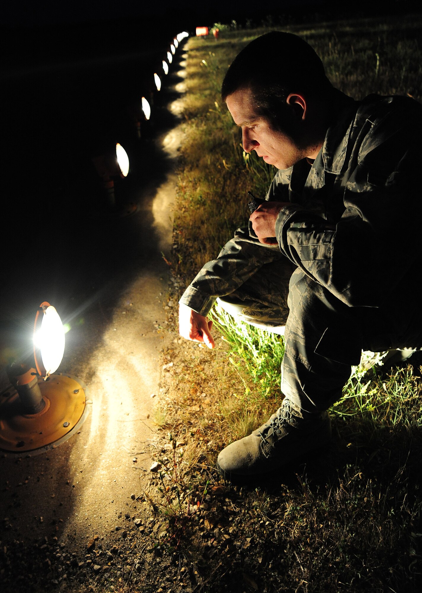 WHITEMAN AIR FORCE BASE, Mo. -- Airman 1st Class Tyler Goswick, 509th Operations Support Squadron airfield management operations coordinator, ensures runway edge lights are operational during a routine inspection June 30. Airfield management personnel communicate with the air traffic control tower to ensure lights on the runway are visible to the pilots in the air. (U.S. Air Force photo/Senior Airman Nick Wilson) (Released)