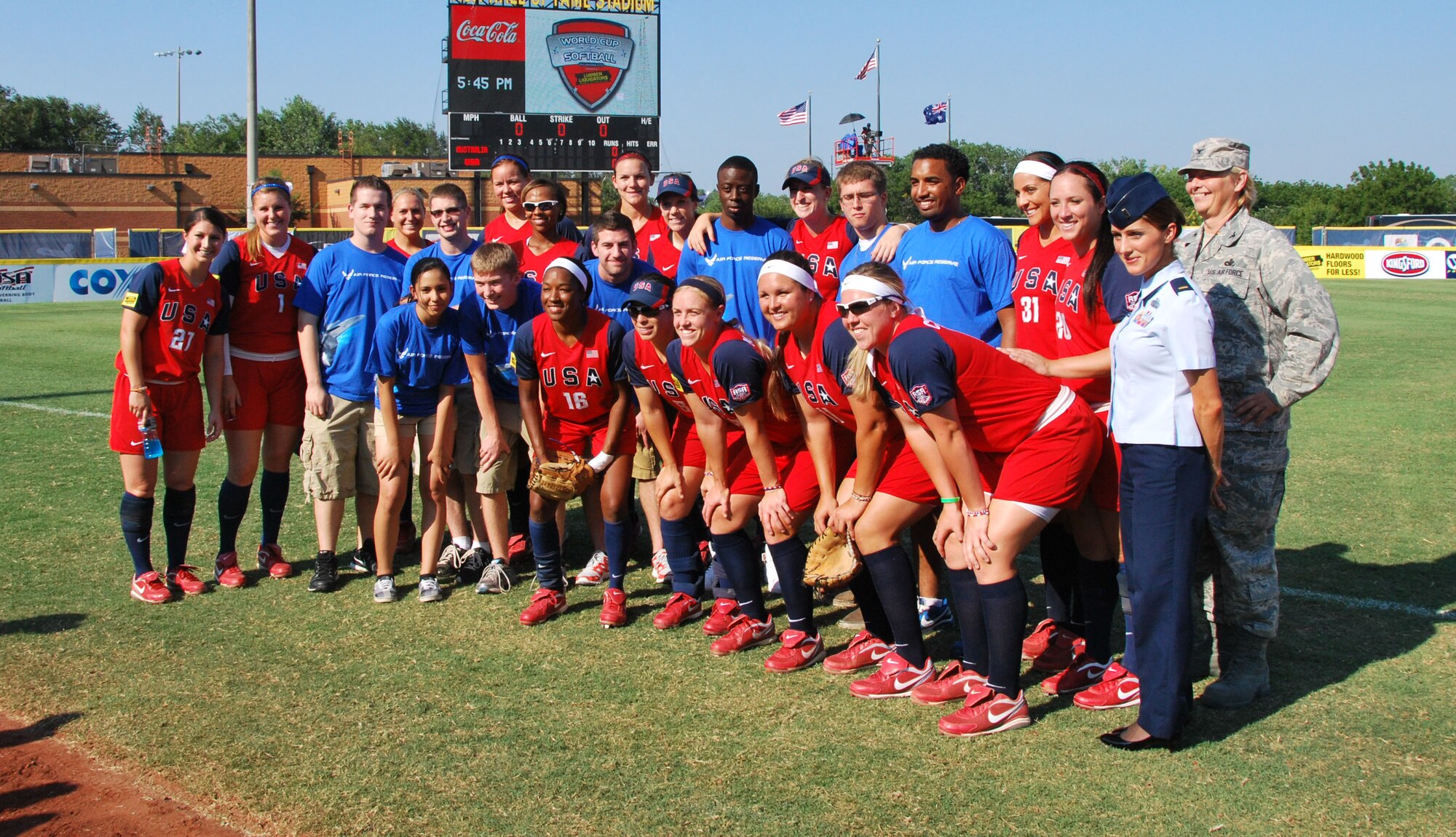 New Air Force Reserve recruits pose with members of the USA Woman's Softball team June 29.  The recruits along with 2nd Lt. Bobbiejean Johnson and Col. MaryAnn Lutz took part in the military appreciation night opening ceremonies prior to the USA versus Australia  game.