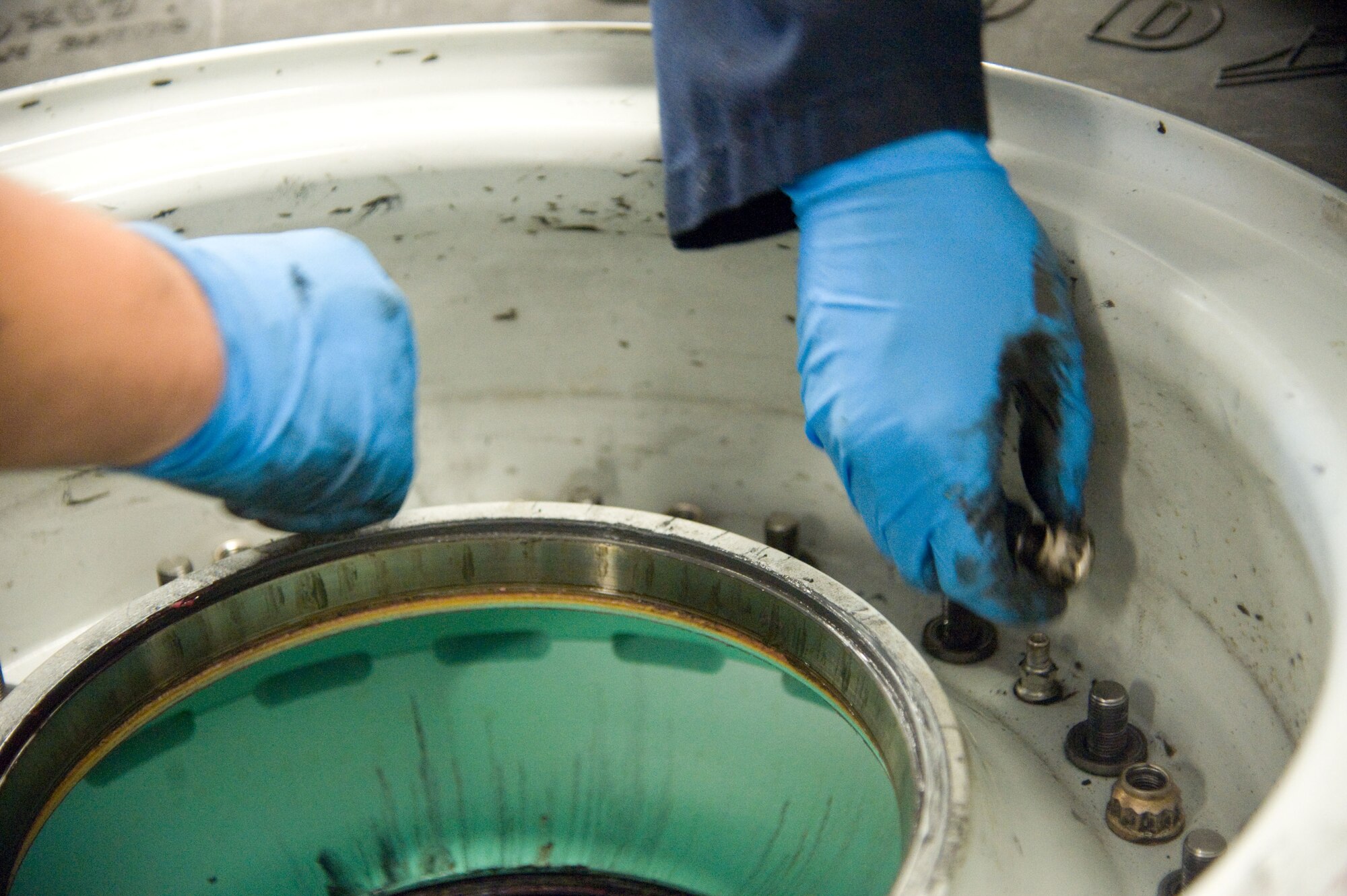 Members of the 436th Maintenance Squadron wheel and tire section gather bolts from a C-5M Super Galaxy nose tire July 9, 2012, at Dover Air Force Base, Del. The inspection rotation on all tires has recently dropped 60 days, increasing the workload for the wheel and tire section. (U.S. Air Force photo by Adrian R. Rowan)