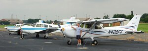 Jim Booth, Aero Club flight instructor, pauses to show off a few of the aircraft at the Aero Club at Langley Air Force Base, Va., July 9, 2012.  The club offers three different courses available for base military and civilian personnel to learn how to fly. (U.S. Air Force photo by Airman 1st Class Kayla Newman/Released)