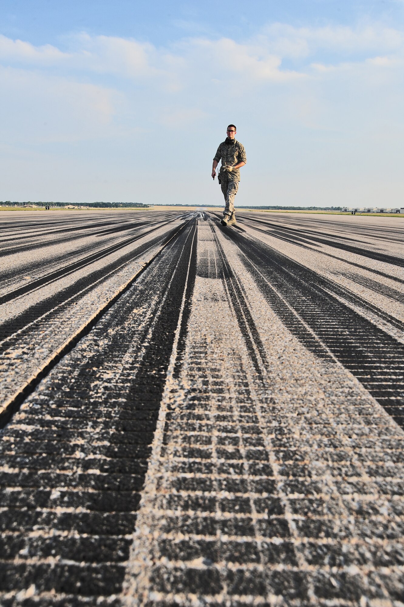 WHITEMAN AIR FORCE BASE, Mo. -- Senior Airman Dennis Myles, 509th Operations Support Squadron airfield management shift lead, performs a daily safety inspection on the runway June 30. One of Myles’ responsibilities is ensuring aircraft are able to safely land and take off on the runway at a moment’s notice. (U.S. Air Force photo/Senior Airman Nick Wilson) (Released)