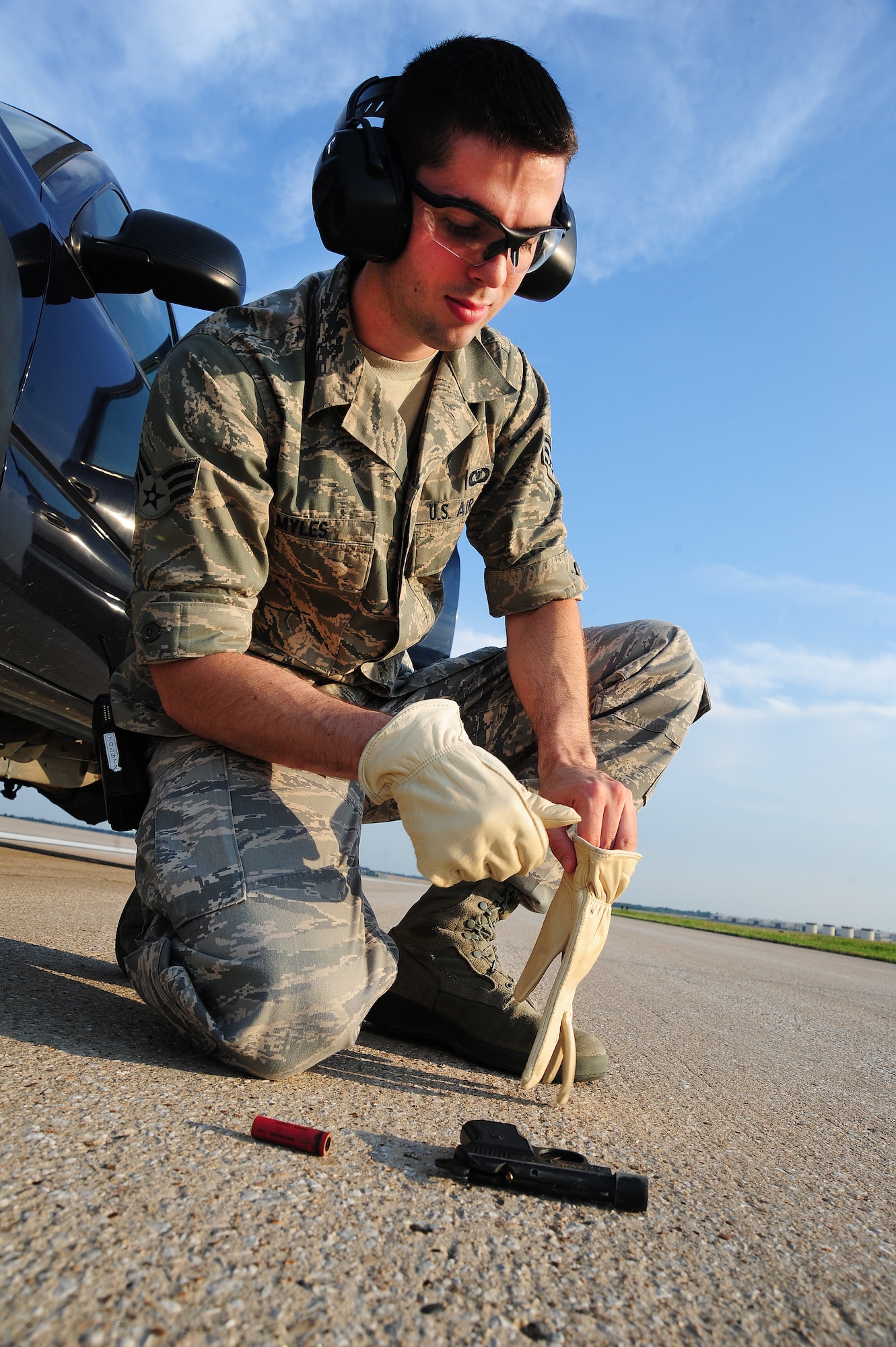 WHITEMAN AIR FORCE BASE, Mo. -- Senior Airman Dennis Myles, 509th Operations Support Squadron airfield management shift lead, puts on gloves before shooting pyrotechnics June 30. Shooting pyrotechnics helps airfield management personnel scare off birds that pose a threat to nearby aircraft. (U.S. Air Force photo/Senior Airman Nick Wilson) (Released)