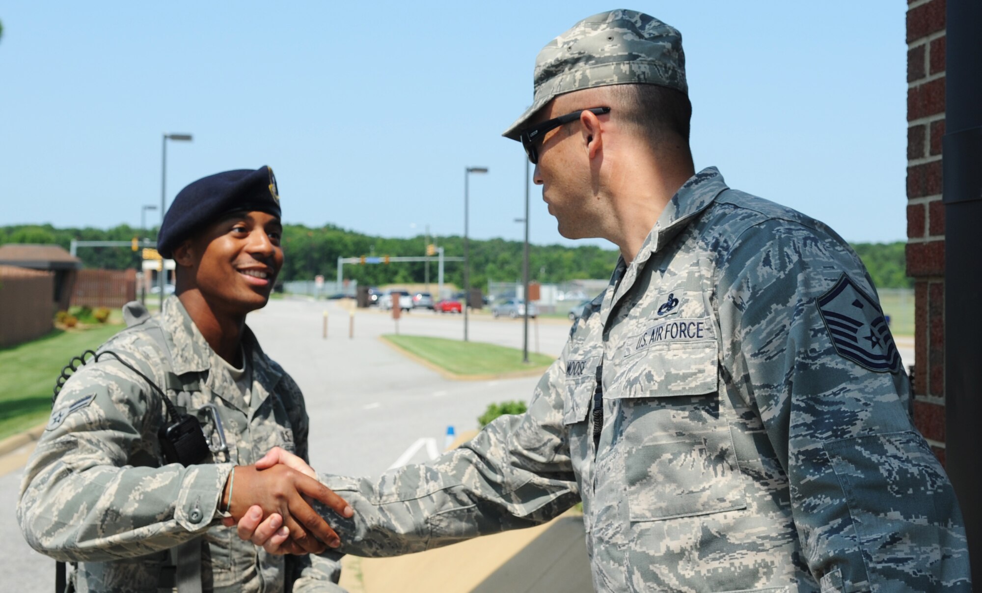Master Sgt. Kelly Moose, 1st Aircraft Maintenance Squadron first sergeant, shakes hands with a Security Forces Airman, June 28, 2012, at Langley Air Force Base, Va. Moose and Senior Master Sgt. Joshua Tidwell, 1st Maintenance Squadron First Sergeant, passed out cold drinks to personnel at every gate as a part of Random Acts of Kindness. (U.S. Air Force photo by Airman 1st Class Austin Harvill/Released)