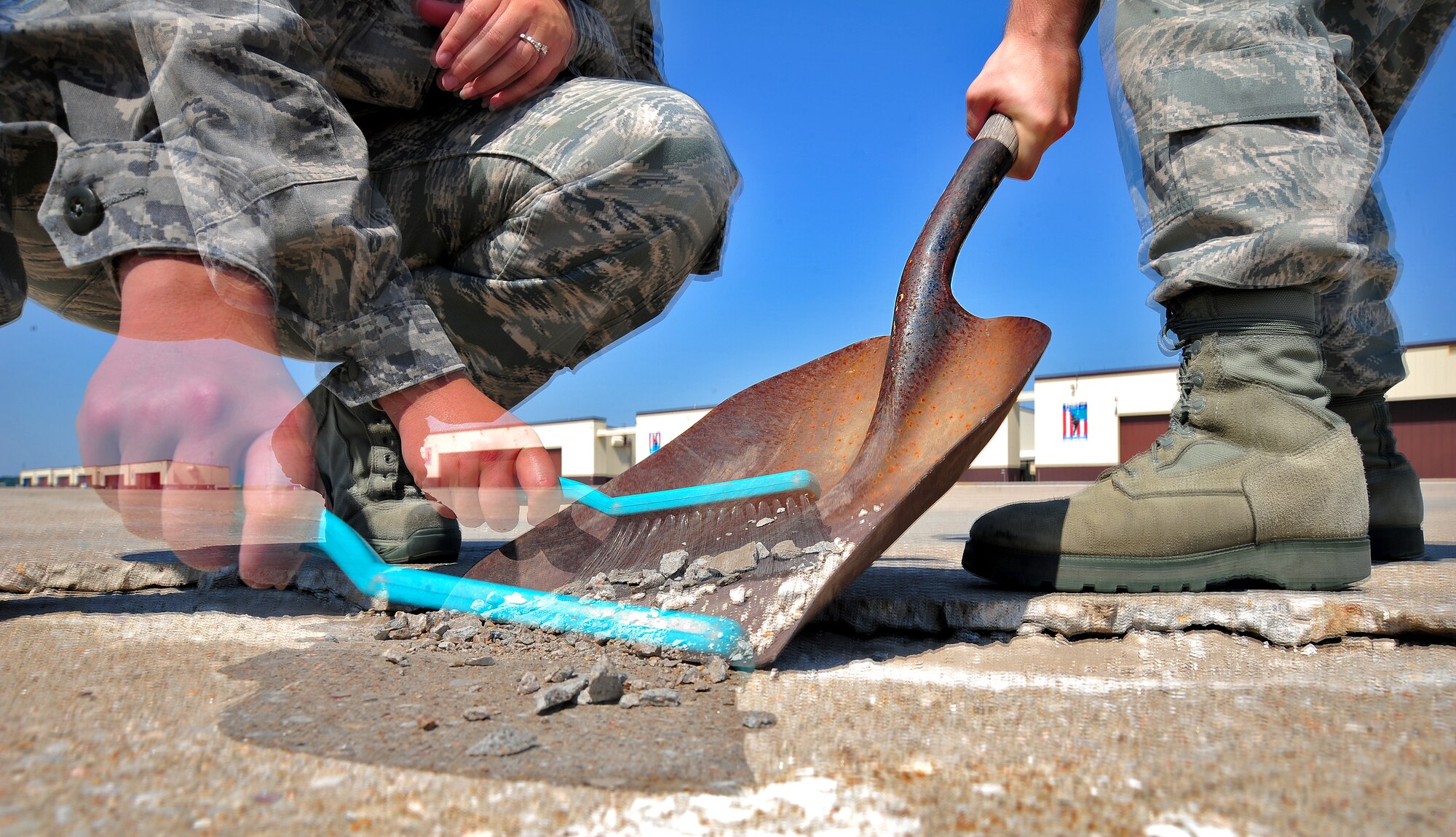 WHITEMAN AIR FORCE BASE, Mo. -- Airmen from the 509th Operations Support Squadron airfield management operations flight sweep up pieces of loose pavement from the airfield June 29, as part of an inspection for items that could cause foreign object damage. Airmen working in the airfield management flight play a critical safety role as a primary means to protect flightline assets and personnel. (U.S. Air Force photo/Senior Airman Nick Wilson) (Released)