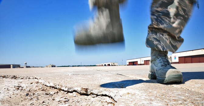 WHITEMAN AIR FORCE BASE, Mo. -- An Airman from the 509th Operations Support Squadron airfield management operations flight stomps on cracked pavement to check solidity as part of a routine flightline inspection June 29. The intent of this inspection is to clear the flightline of debris that can potentially damage aircraft engines. (U.S. Air Force photo/Senior Airman Nick Wilson) (Released)
