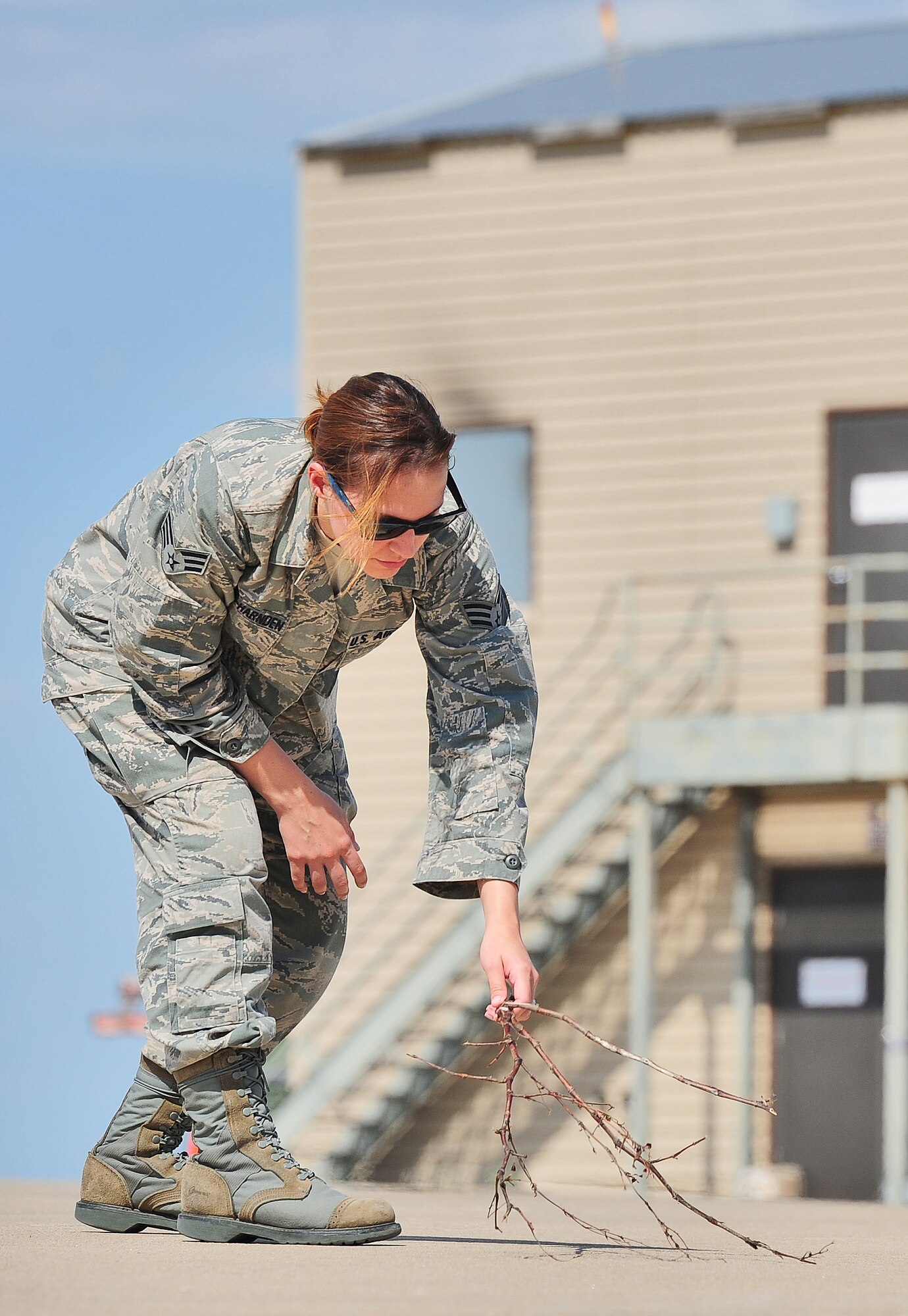 WHITEMAN AIR FORCE BASE, Mo. -- Senior Airman Alessandra Aceves-Harnden, 509th Operations Support Squadron airfield management shift lead, collects loose debris that could potentially harm an aircraft June 7.Whiteman’s airfield management team manages everything from broken equipment and pavement cracks to wild animals that could pose a threat to aircraft on the runway. (U.S. Air Force photo/Senior Airman Nick Wilson) (Released)