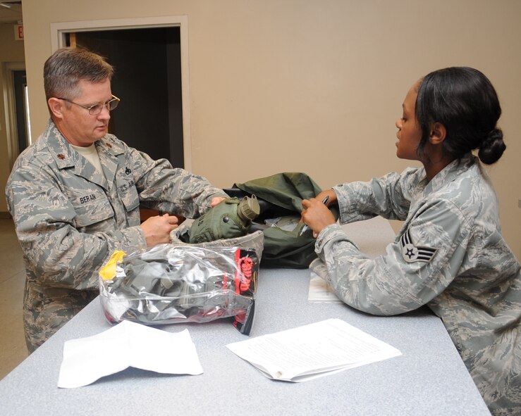 Maj. Gordon Beran, 2nd Maintenance Squadron operations officer, turns in his gas mask to Senior Airman Taylor Leach, 2nd Logistics Readiness Squadron mobility apprentice, on Barksdale Air Force Base, La., July 9. The 2 LRS mobility section is responsible for handling and distributing all mobility and training gear, and weapons that are given to Airmen who are deploying to the overseas. Issued gear includes a sleeping system, gas mask, boots and gloves. (U.S. Air Force photo/ Senior Airman Sean Martin)(RELEASED)