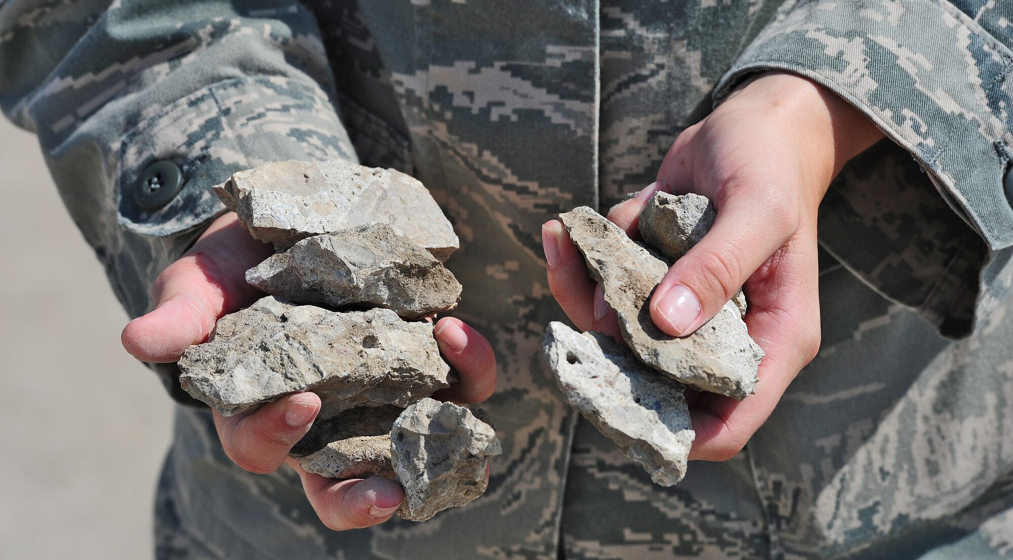 WHITEMAN AIR FORCE BASE, Mo. -- Senior Airman Alisha Thiher, 509th Operations Support Squadron airfield management journeyman, collects loose pieces of pavement from the flightline as part of an inspection June 29, for items that could cause foreign object damage.  FOD can be any number of things including rocks, bags, garbage or objects dropped from aircraft. The smallest piece of FOD can destroy an entire aircraft engine. (U.S. Air Force photo/Senior Airman Nick Wilson) (Released)

