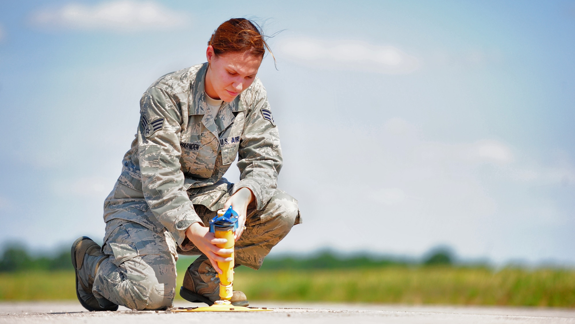 WHITEMAN AIR FORCE BASE, Mo. -- Senior Airman Alessandra Aceves-Harnden, 509th Operations Support Squadron airfield management shift lead, collects loose pieces of concrete from the flightline June 7 as part of an inspection for items that could cause foreign object damage. It is paramount for airfield managers to ensure the aircraft is clear from FOD items at all times. (U.S. Air Force photo/Senior Airman Nick Wilson) (Released)