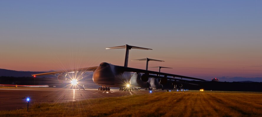 Spotlights, taxiing lights and the sunset illuminate the C-5 Galaxys at Westover Air Reserve Base, Chicopee, Mass., on July 7, 2012. The C-5 is able to takeoff fully loaded within 8,300ft and land within 4,900ft with 28 wheels of landing gear sharing the weight. (U.S. Air Force photo/SrA. Kelly Galloway)