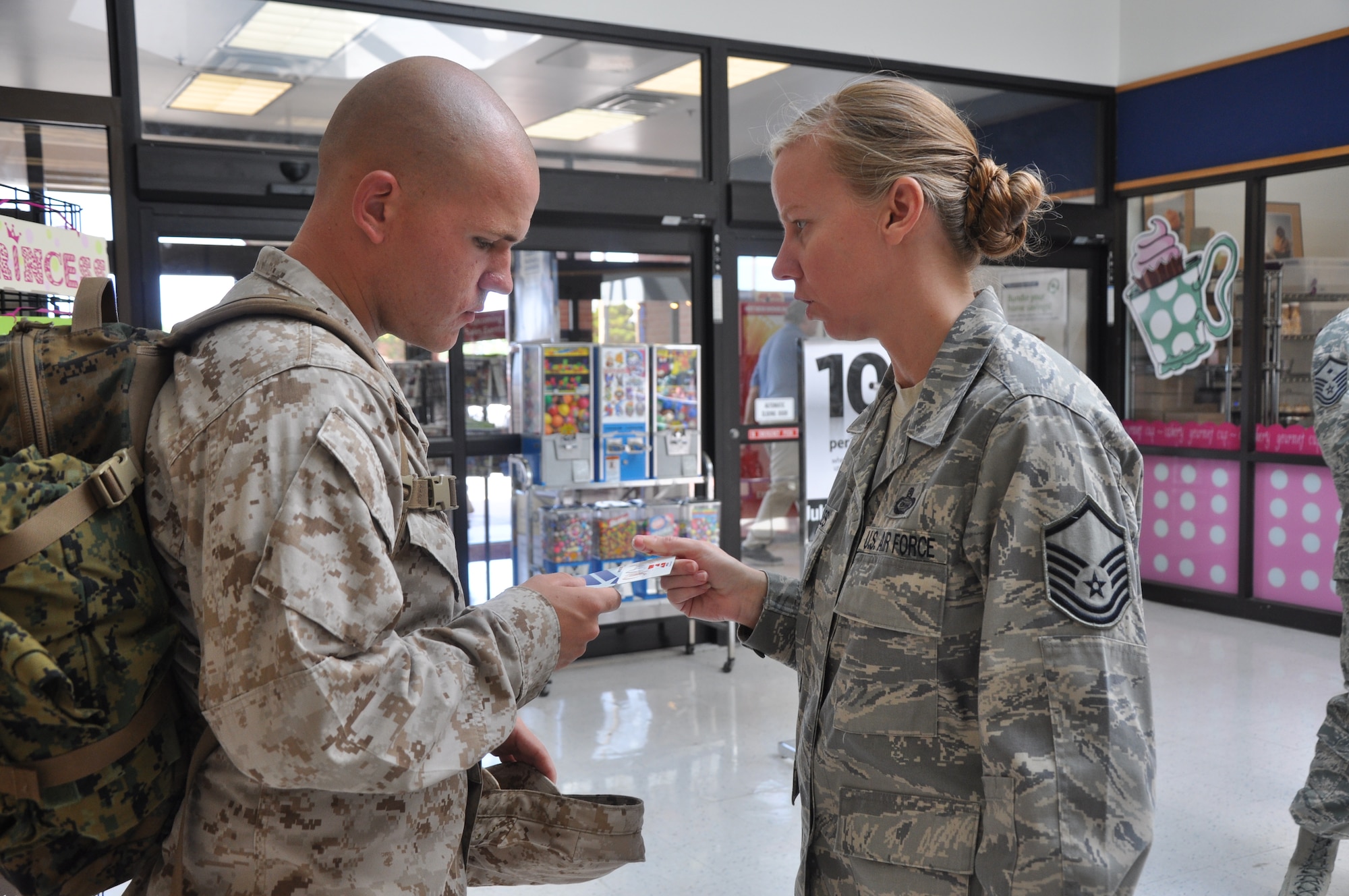 Master Sgt. Ina Peeples, 315th Training Squadron first sergeant, gives  Pfc. Joshua Beauvais, Marine Corps Detachment, a $20 AAFES gift card July 3. Goodfellow first sergeants randomly handed out gift cards totaling $500 to servicemembers. (U.S. Air Force photo/Senior Airman Anne Gathua)