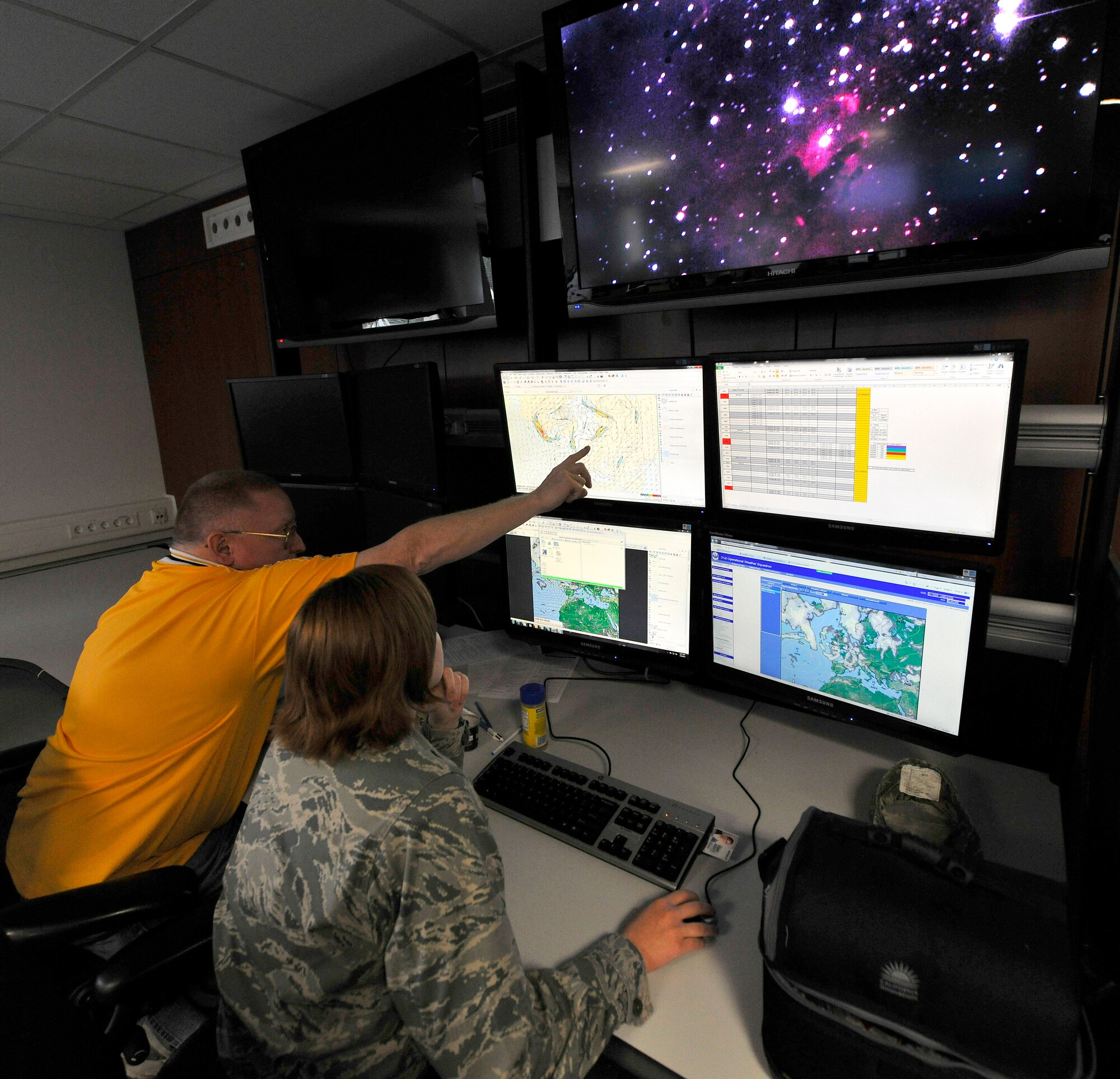 Lt. Shannon Kranich, 21st Operational Weather Squadron synoptic element OIC, and Randall Ritchie, 21st Operational Weather Squadron synoptic element technical manager, review the surface frontal charts on Kapuan Air Station, Germany, July 6, 2012. The 21st OWS operates with more than 200 assigned personnel providing routine flight weather briefings for senior weather leaders along with five day forecasts to help keep more than 50K personnel informed of expected weather conditions and aid in protecting over $30 billion worth of DoD assets.  (U.S. Air Force photo/Senior Airman Chris Willis)