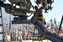 MINOT AIR FORCE BASE, N.D. -- Senior Airman Adam Gonzalez, 5th Aircraft Maintenance Squadron load crew member, ensures the weapon is being placed properly during a weapons load competition here, July 3. As with most team-driven competitions, it was imperative that crews worked together in order to achieve the fastest time and outscore their opponents. (U.S. Air Force photo/Senior Airman Brittany Y. Auld)