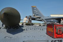 MINOT AIR FORCE BASE, N.D. -- Staff Sgt. John McFarland and Senior Airman Adam Gonzalez, 5th Aircraft Maintenance Squadron load crew members, ensure the weapon is placed correctly on the MJ-1 Jammer during a weapons load competition here July 3. As with most team-driven competitions, it was imperative that crews worked together in order to achieve the fastest time and outscore their opponents. (U.S. Air Force photo/Senior Airman Brittany Y. Auld))