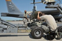 MINOT AIR FORCE BASE, N.D. -- Staff Sgt. John McFarland and Senior Airman Adam Gonzalez, 5th Aircraft Maintenance Squadron load crew members, ensure the weapon is placed correctly on the MJ-1 Jammer during a weapons load competition here July 3. As with most team-driven competitions, it was imperative that crews worked together in order to achieve the fastest time and outscore their opponents. (U.S. Air Force photo/Senior Airman Brittany Y. Auld))