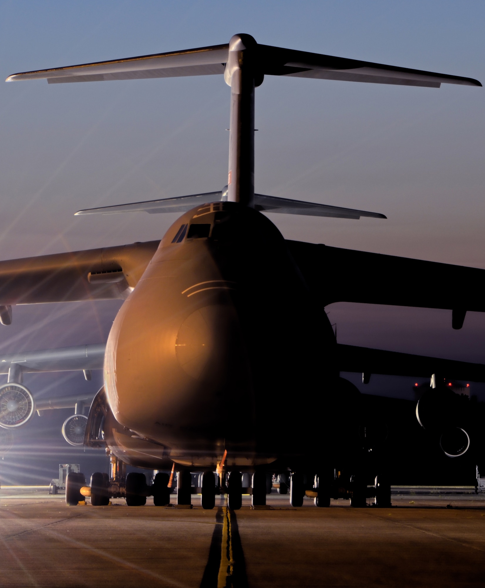Spotlights illuminate Westover Air Reserve Base's C-5s to ensure security of the aircraft, July 7, 2012. Since 1987, Westover has been participating in worldwide humanitarian relief efforts and war operations with the cargo and troop transport, the C-5 Galaxy.). A C-5 with a cargo load of 270,000 pounds can fly 2,150 nautical miles, offload, and fly to a second base 500 nautical miles away from the original destination without aerial refueling. (U.S. Air Force photo/SrA. Kelly Galloway)