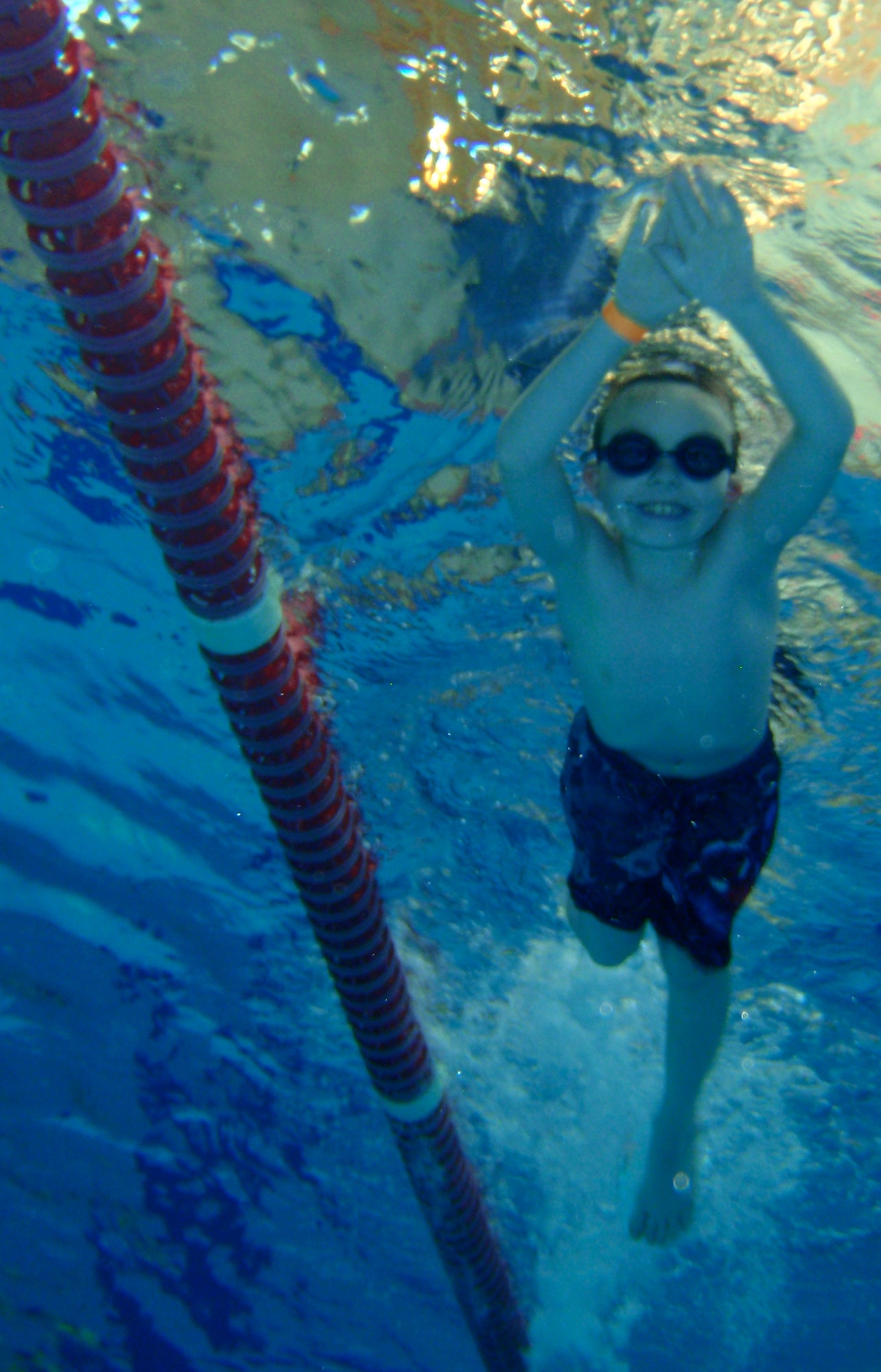 Gyrenn Precup practices his stream-line off the wall during their swim lesson at the Aquatics Center here June 29. Swim lessons teach children life-long skills of patience, practice, water safety and helps build social skills. (U.S. Air Force photo/Airman 1st Class Hailey Haux)