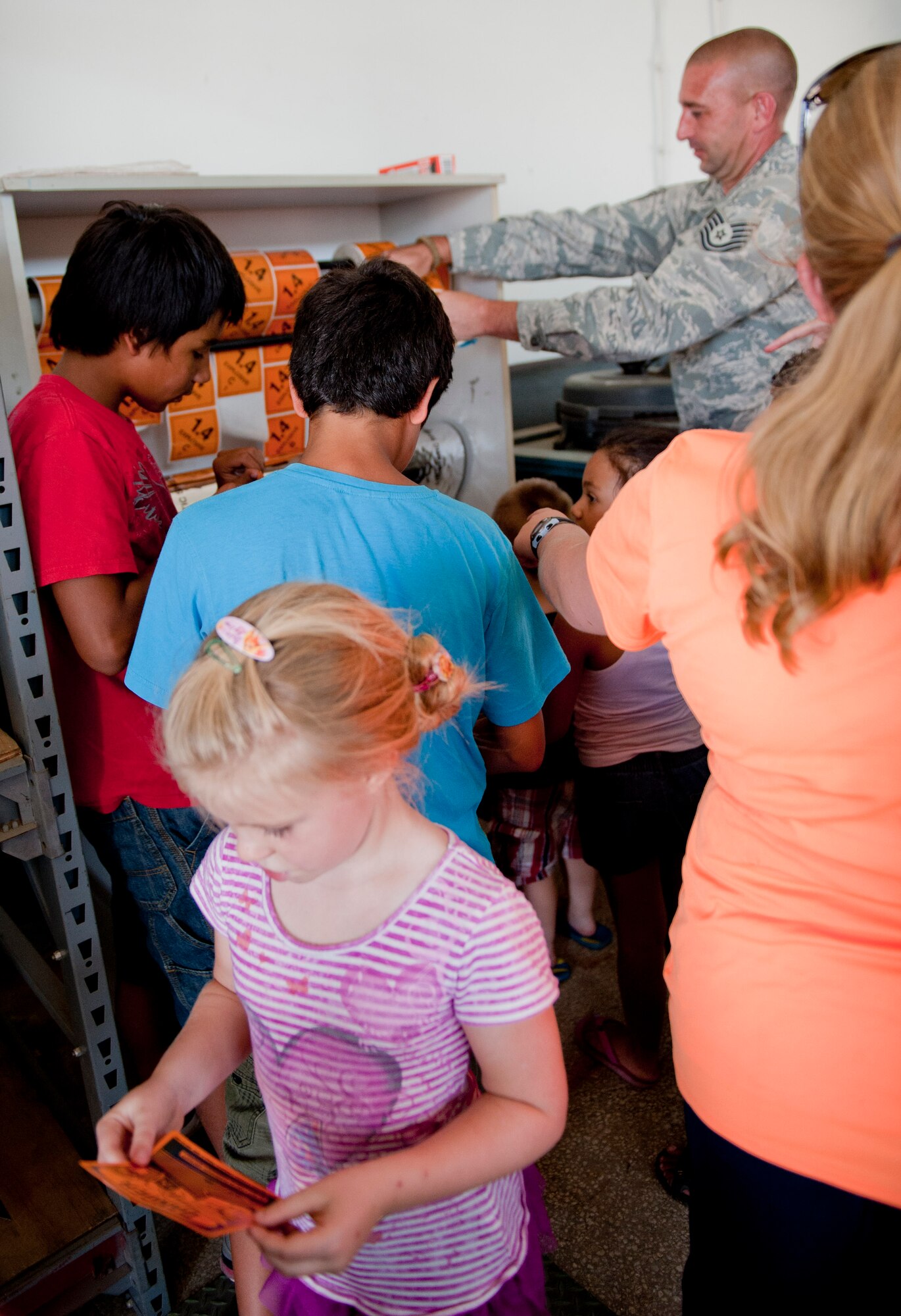Tech. Sgt. Brian Stanford, 39th Maintenance Squadron conventional weapons maintainer, hands out explosive hazard stickers to spouses and children during a squadron tour July 6, 2012, at Incirlik Air Base, Turkey. The stickers are used to identify different types of hazardous materials such as poisons, explosives and flammable substances. (U.S. Air Force photo by Senior Airman Anthony Sanchelli/Released)