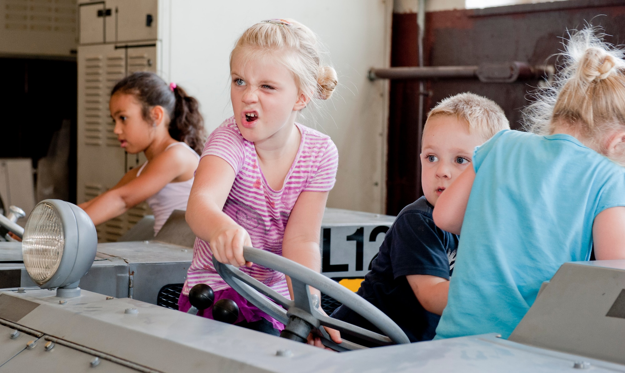 Children of 39th Maintenance Squadron Airmen playfully inspect an MJ-1B bomb lift during a squadron tour July 6, 2012, at Incirlik Air Base, Turkey. The tour was created for family members and friends of 39th MXS Airmen who wished to see and know more about what their loved one does at work. (U.S. Air Force photo by Senior Airman Anthony Sanchelli/Released)