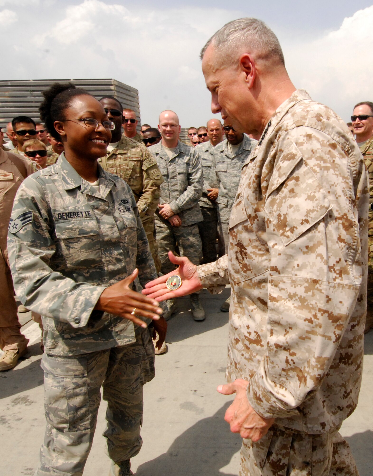 Senior Airman Maranda Generette, 104th Expeditionary Fighter Squadron, is “coined” by Marine Corps Gen. John Allen, International Security Assistance Force commander, during his visit to Bagram Airfield, Afghanistan, July 8, 2012. The general stopped through Bagram to speak to 104 EFS and to “coin” some members of the squadron for their outstanding performances before they redeploy home. (U.S. Air Force photo/Staff Sgt. Jeff Nevison)