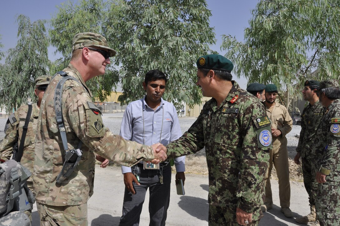 AFGHANISTAN — Air Force Col. Benjamin Wham, Afghanistan Engineer District South commander, and Lt. Col. Mohammad Isreal, Kandahar Air Wing vice commander, exchange greetings July 7, 2012, at the 205th Air Corps Cantonment on Kandahar Airfield, Afghanistan. The U.S. Army Corps of Engineers, together with the U.S. Air Force and ITT Exelis, trained and mentored the Afghans who will assume facility operations and maintenance responsibilities on the Air Wing cantonment.