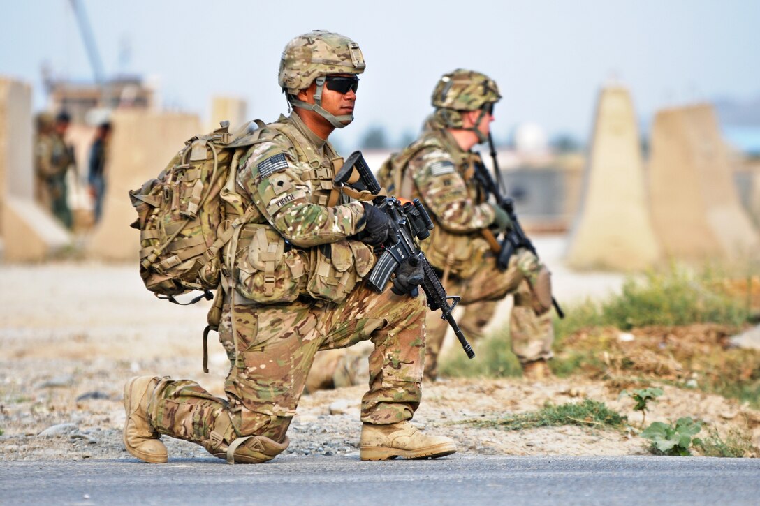 U.S. Army Spc. John Yifith, front, takes a knee while conducting a security patrol outside 
Forward Operating Base Salerno in Afghanistan's Khowst province, July 7, 2012. Yifith, an assistant gunner, is assigned to the 2nd Battalion (Airborne), 377th Field Artillery Regiment. The patrol was conducted to support members of the female engagement team as they participated in key leader engagement at a girls' school in the Mangas village and visited the village of Kunday to discuss the midwife program. 