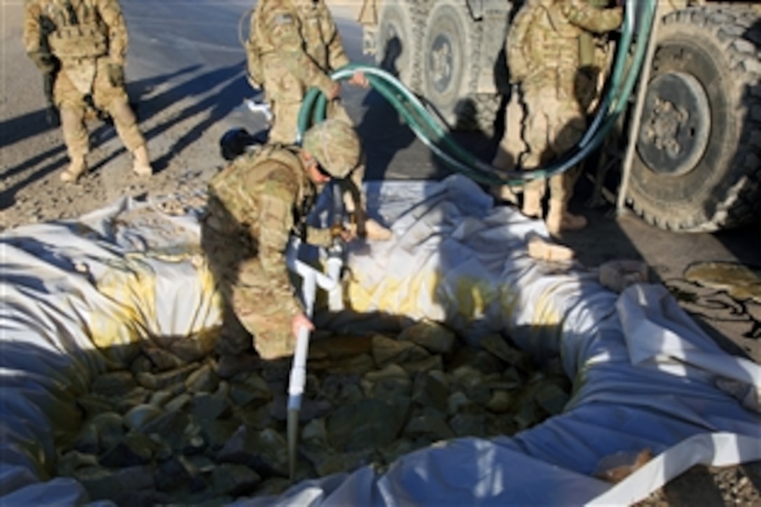 U.S. Army Pfc. Thomas Duquette pours a liquid substance into what used to be a crater on Route 1, near Forward Operating Base Arian, Ghazni province, Afghanistan, June 27, 2012. Duquette is assigned to the 82nd Airborne Division's Company A, 1st Brigade Special Troops Battalion.