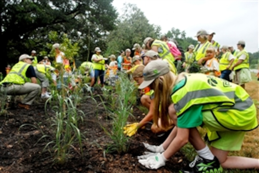 Children plant milkweed to attract Monarch butterflies during the 16th annual Renewal and Remembrance Volunteer Day of Service at Arlington National Cemetery, Arlington, Va., July 9, 2012. Monarch larvae feed exclusively on milkweed. The children joined hundreds of landscapers and lawn care professionals as volunteers for a day of service to help maintain the more than 600 acres of cemetery grounds.