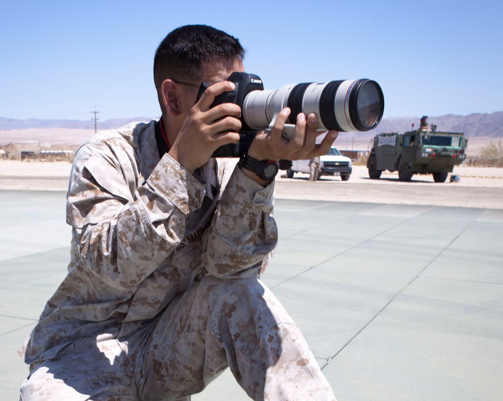 MARINE CORPS AIR GROUND COMBAT CENTER TWENTYNINE PALMS, Calif. - Sgt. Kevin Okamura, a combat cameraman with 1st Marine Expeditionary Force documents a refuel for an AH-1W Super Cobra attack helicopter at the Strategic Expeditionary Landing Field here July 9 during Exercise Javelin Thrust 2012. Javelin Thrust 2012 is an annual large scale exercise at Marine Corps Air Ground Combat Center Twentynine Palms, Calif., which allows active and reserve Marines and Sailors from 38 different states to train together as a seamless Marine Air Ground Task Force. (Official U.S. Marine Corps photo by Sgt. John M. Odette/Released)