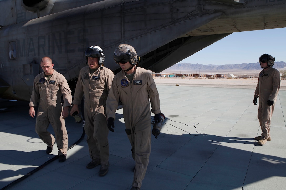 MARINE CORPS AIR GROUND COMBAT CENTER TWENTYNINE PALMS, Calif. - CH-53E Super Stallion helicopter crew chiefs from Marine Heavy Helicopter Squadron 772, Sgt. Robert Brensinger, Sgt. Greg Farren, and Staff Sgt. David Scranton prepare fuel lines for a ground refueling mission here while Cpl. Kevin McClernon keeps an eye on the aircraft during Exercise Javelin Thrust July 9. Javelin Thrust is an annual large-scale exercise which allows active and reserve Marines and sailors from 38 different states to train together as a seamless Marine Air Ground Task Force. (photo by Master Sgt. Chris W. Cox)