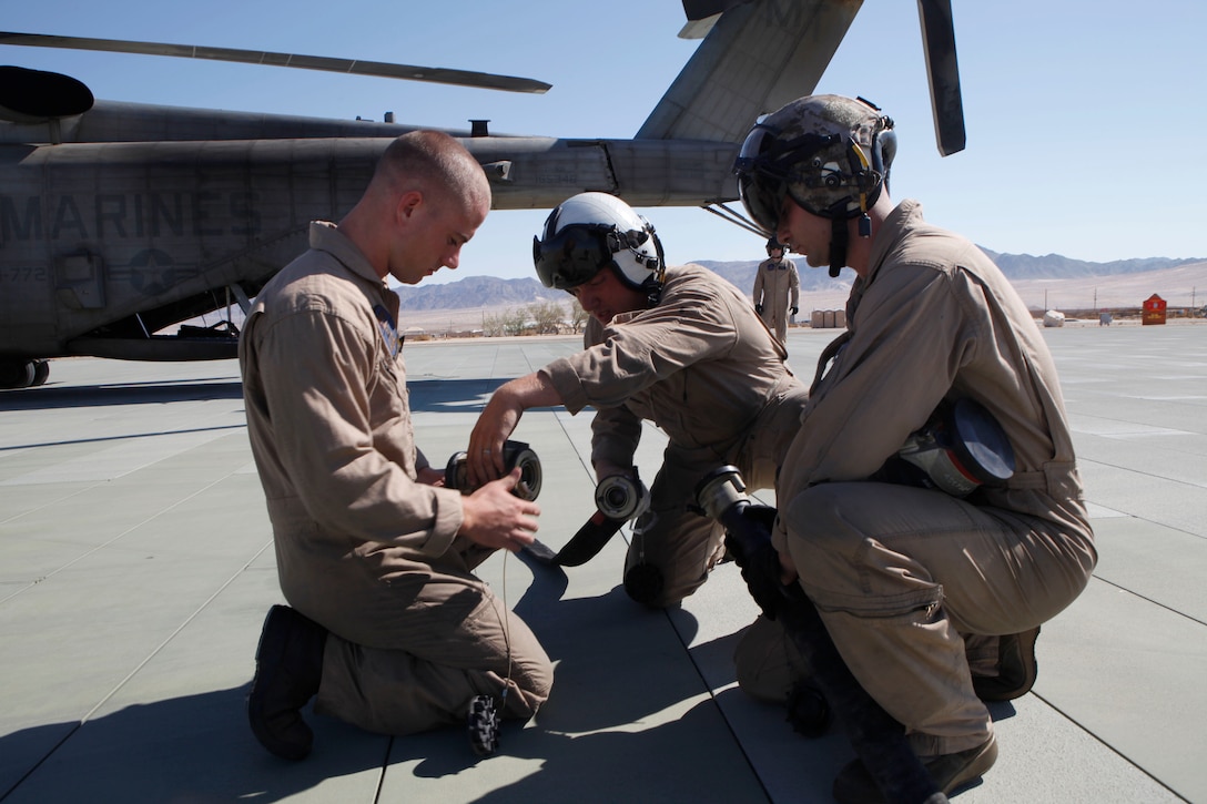 MARINE CORPS AIR GROUND COMBAT CENTER TWENTYNINE PALMS, Calif. - CH-53E Super Stallion helicopter crew chiefs from Marine Heavy Helicopter Squadron 772, Sgt. Robert Brensinger, Sgt. Greg Farren, and Staff Sgt. David Scranton prepare fuel lines for a ground refueling mission here while Cpl. Kevin McClernon keeps an eye on the aircraft during Exercise Javelin Thrust July 9. Javelin Thrust is an annual large-scale exercise which allows active and reserve Marines and sailors from 38 different states to train together as a seamless Marine Air Ground Task Force. (photo by Master Sgt. Chris W. Cox)