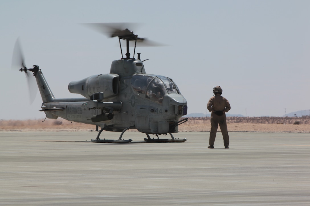 MARINE CORPS AIR GROUND COMBAT CENTER TWENTYINE PALMS, Calif. - CH-53E crew chief Cpl. Kevin McClernon from Marine Heavy Helicopter Squadron 772 prepares a AH-1W Super Cobra helicopter to taxi after refueling during Exercise  Javelin Thrust  2012. Javelin Thrust is an annual large-scale exercise which allows active and reserve Marines and Sailors from 38 different states to train together as a seamless Marine Air Ground Task Force. (Photo by Sgt. Kevin M. Okamura/Released)