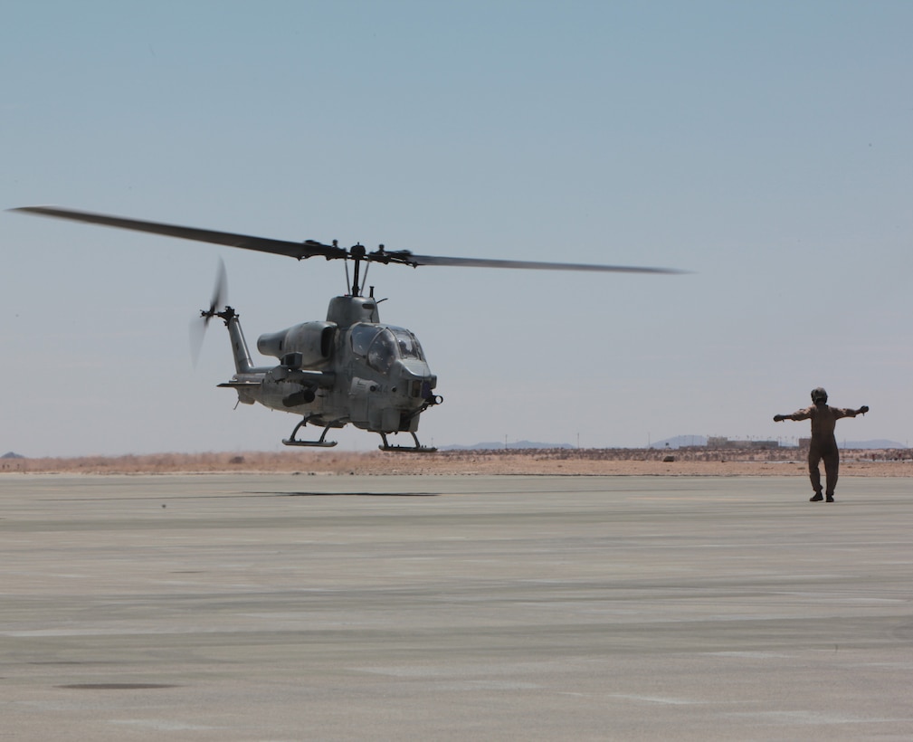 MARINE CORPS AIR GROUND COMBAT CENTER TWENTYNINE PALMS, Calif. - Cpl. Kevin McClernon from Marine Heavy Helicopter Squadron 772 signals an AH-1W Super Cobra helicopter to hover after refueling at the Strategic Expeditionary Landing Field here during Exercise Javelin Thrust  2012. Javelin Thrust is an annual large-scale exercise which allows active and reserve Marines and Sailors from 38 different states to train together as a seamless Marine Air Ground Task Force. (Marine Corps Photo by Sergeant Kevin M. Okamura/Released)