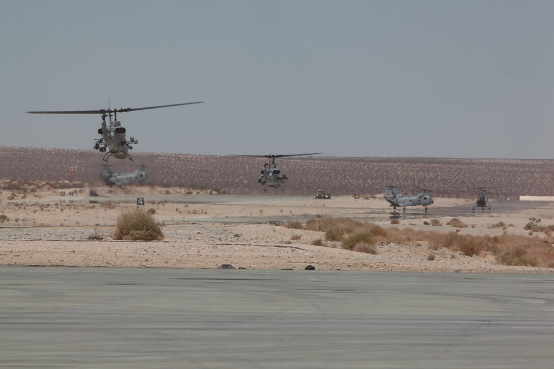 MARINE CORPS AIR GROUND COMBAT CENTER TWENTYNINE PALMS, Calif. - Two AH-1W Super Cobra helicopters return to missions after refueling at the Strategic Expeditionary Landing Field here during Exercise Javelin Thrust 2012. Javelin Thrust is an annual large-scale exercise which allows active and reserve Marines and Sailors from 38 different states to train together as a seamless Marine Air Ground Task Force. (Photo by Sgt. Kevin M. Okamura/Released)