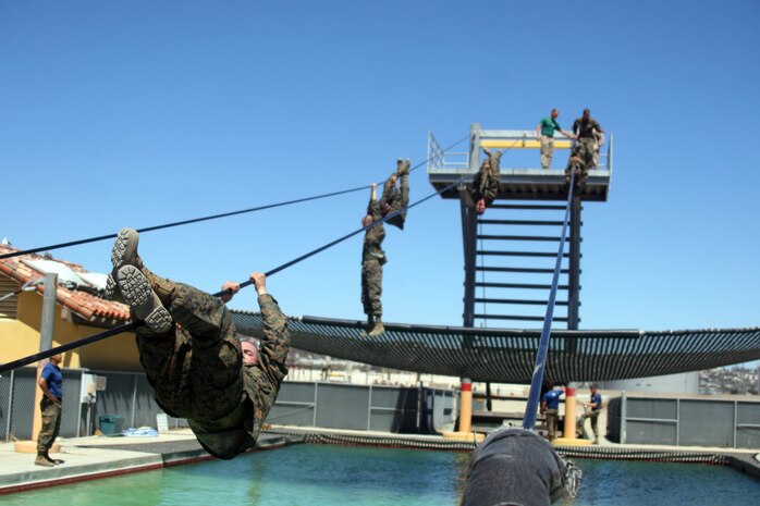 The slide for life is an obstacle that requires recruits to climb a 25-foot tower, then climb across a decesending 90-foot cable above a pool of water. Halfway through the climb, recruits are instructed to change posistions while hanging above the pool. This obstacle requires the most mental and physical strength to complete.