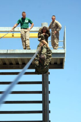 A recruit traverses down a 90-foot cable while instructors encourage him to hang on to the slide for life during Confidence Course II June 26 aboard Marine Corps Recruit Depot San Diego. The Confidence Course allows recruits to build self-confidence and feel accomplished when completing an obstacle, it also helps build mental and physical strength. 