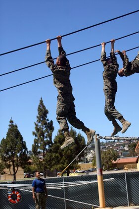 A drill instructor of Company L instructs recruits to change positions while they hold on to a cable above a pool during Confidence Course II June 26 aboard Marine Corps Recruit Depot San Diego. The slide for life is one of the most challenging obstacles of the course because the recruits lose themselves in fear.  