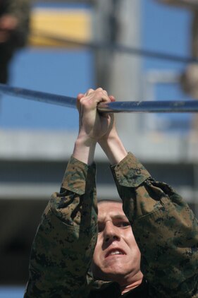 A recruit uses all his strength to hold on to the cable while switching positions on the slide for life during Confidence Course II June 26 aboard Marine Corps Recruit Depot San Diego. The course allows recruits to face fears to overcome obstacle and become more confident in their abilities.