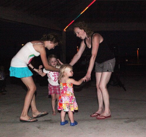 Two mothers danced with their daughters during the Flashback Fridays classic rock-theme event hosted by Marine Corps Community Services at Onslow Beach aboard Marine Corps Base Camp Lejeune July 6. The disc jockey played classic rock from the 50s up to the 90s. 