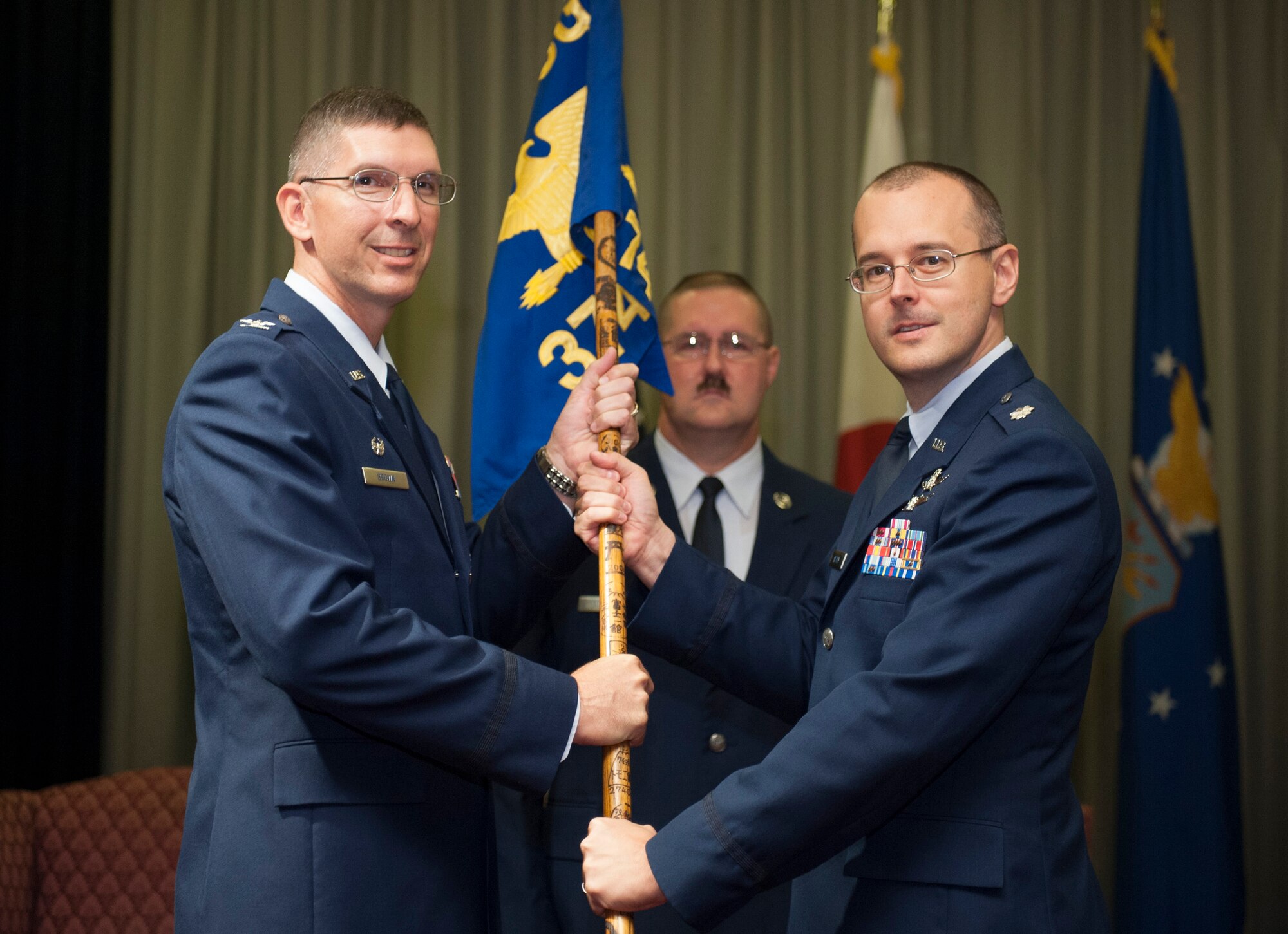 YOKOTA AIR BASE, Japan -- Col. Edward Brown, left, 374th Mission Support Group commander, passes the 374th Communications Squadron guidon to Lt. Col. Jon Autrey, the new 374th Communications Squadron commander, during the 374 CS change of command ceremony at Yokota Air Base, Japan, July 6, 2012. Passing the unit guidon is symbolic of passing the responsibility of command, a tradition dating back to Roman times. (U.S. Air Force photo by Tech. Sgt. Samuel Morse)