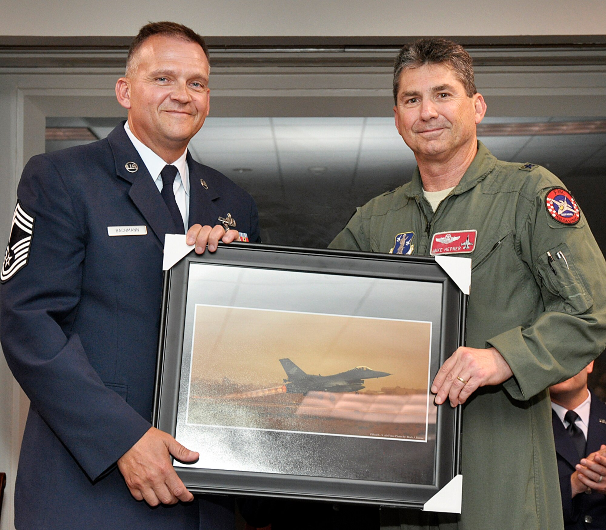 Brigadier General Michael Hepner presented an F-16 photograph to Chief Master Sergeant Randy Bachmann, Detachment 1, Chief Enlisted Manager, in honor of his 26 year Air Force career at a retirement ceremony held 28 June 2012, at Ellington Field, Houston Texas.  CMSgt Bachmann served 20 of his 26 years at alert detachments. 