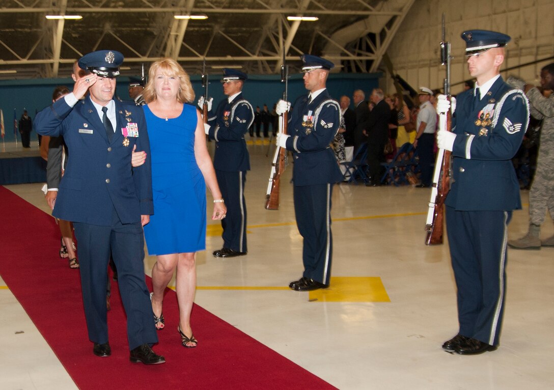 Col. Ken Rizer, former 11th Wing/Joint Base Andrews commander, walks along side his wife Cherilyn Rizer and renders a final salute at the conclusion of the 11th Wing Change of Command ceremony held in Hangar 3 here July 6. (Photo/Bobby Jones)