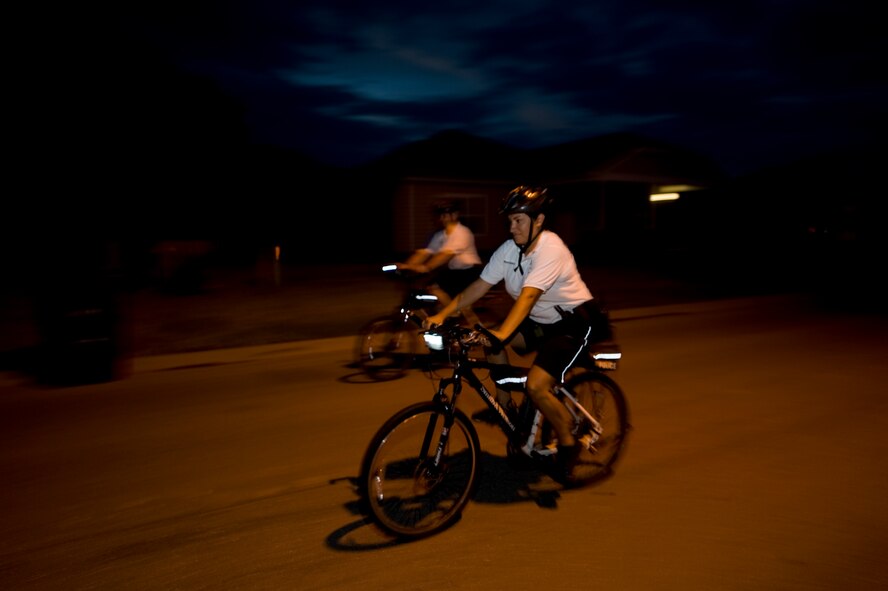 Airman 1st Class Sirenna Marindeleon, 7th Security Forces Squadron, rides her bicycle through base housing during night patrol July 9, 2012, at Dyess Air Force Base, Texas. From May to September, officers in groups of two ride throughout Dyess assisting with situations that may occur. Dyess base housing has paths that patrol cars aren’t able to navigate, but the bike patrol is able to ensure they’re secured. The patrols not only keep the neighborhoods safe, they also help build rapport with residents. (U.S. Air Force photo by Airman 1st Class Damon Kasberg/Released)